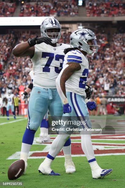 Rico Dowdle of the Dallas Cowboys celebrates a touchdown with Tyler Smith during the second quarter of a game against the Arizona Cardinals at State...