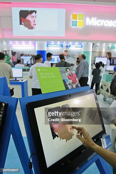 Visitor paints on a Micro-Star International Co. All-in-One PC at the Microsoft Corp. Booth at Computex Taipei 2013 in Taipei, Taiwan, on Tuesday,...