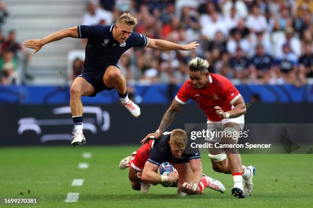 Kyle Steyn of Scotland is tackled by Pita Ahki and Vaea Fifita of Tonga during the Rugby World Cup France 2023 match between Scotland and Tonga at...