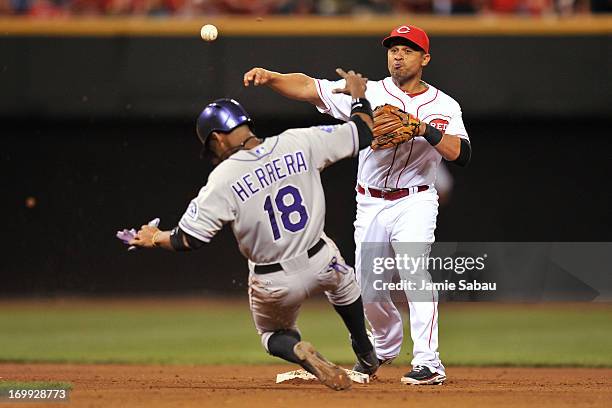 Cesar Izturis of the Cincinnati Reds forces out Jonathan Herrera of the Colorado Rockies and throws to first to complete a double play in the seventh...