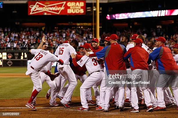 John Mayberry Jr. #15 of the Philadelphia Phillies is met at the plate after hitting a Grand Slam Home Run in the 11th inning to win game against the...