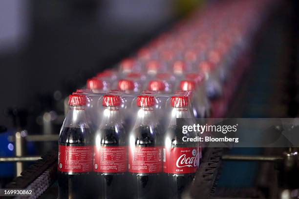 Packaged bottles of Coca-Cola soda move along the production line at the Coca-Cola Co. Bottling plant in Hmawbi, Myanmar, on Tuesday, June 4, 2013....