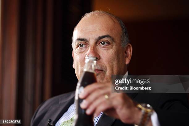 Muhtar Kent, chief executive officer of Coca-Cola Co., holds a bottle of Coca-Cola soda during a Bloomberg Television interview in Yangon, Myanmar,...