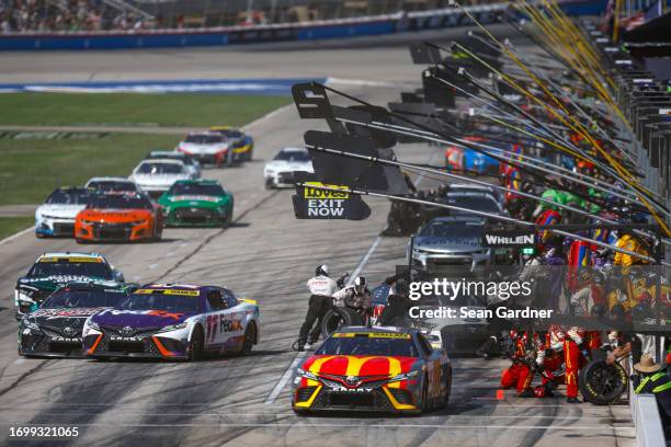 Bubba Wallace, driver of the McDonald's Toyota, exits pit road as Ty Gibbs, driver of the Interstate Batteries Toyota, and Denny Hamlin, driver of...