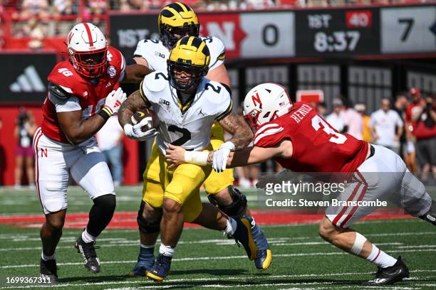 Blake Corum of the Michigan Wolverines breaks a tackle of Nick Henrich of the Nebraska Cornhuskers in the first quarter at Memorial Stadium on...