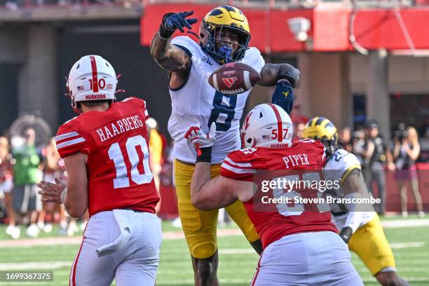 Derrick Moore of the Michigan Wolverines goes around the block of Bryce Benhart of the Nebraska Cornhuskers to knock down a pass from Heinrich...