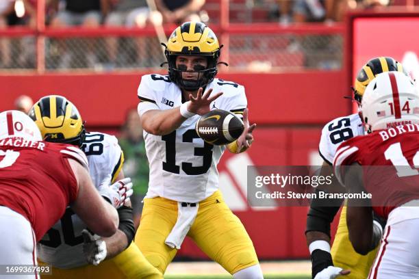 Jack Tuttle of the Michigan Wolverines tales a snap against the Nebraska Cornhuskers in the third quarter at Memorial Stadium on September 30, 2023...