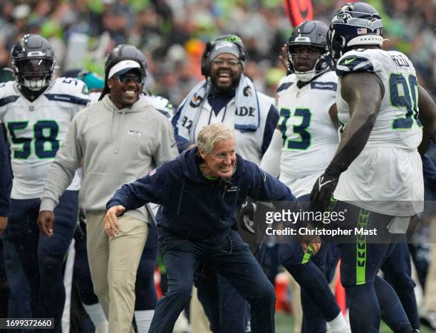 Head coach Pete Carroll of the Seattle Seahawks celebrates with Jarran Reed of the Seattle Seahawks during the fourth quarter against the Carolina...