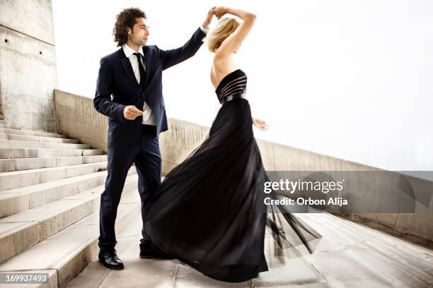 elegante pareja bailando juntos - vestido-de-noche fotografías e imágenes de stock