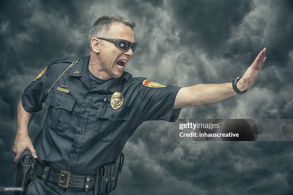 Policeman yelling and gesturing to stop