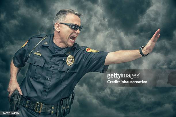 policeman yelling and gesturing to stop - muster point stock pictures, royalty-free photos & images