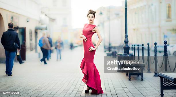 giovane donna in abito rosso sulla città - vestito da sera femminile foto e immagini stock