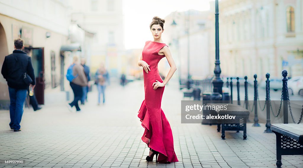 Young woman in red dress on city streets