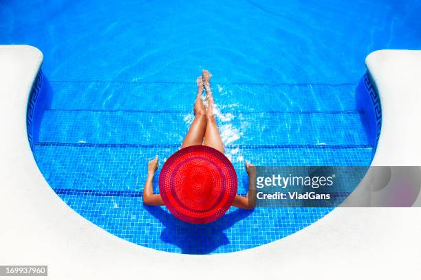 femme se détendre dans la piscine du centre de villégiature - piscine de complexe balnéaire photos et images de collection