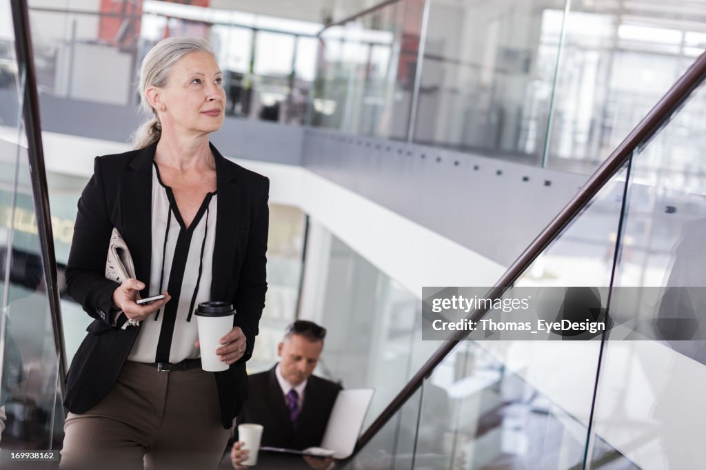 Senior Mulher de Negócios no início do seu dia de trabalho