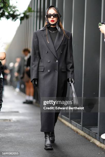 Guest wears sunglasses, a scarf over the head, a black turtleneck top, a long coat, outside Gucci, during the Milan Fashion Week - Womenswear...