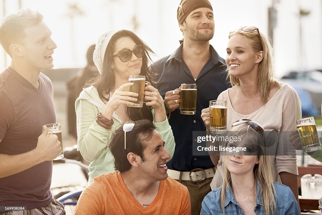 Jovens em bistro com cerveja.