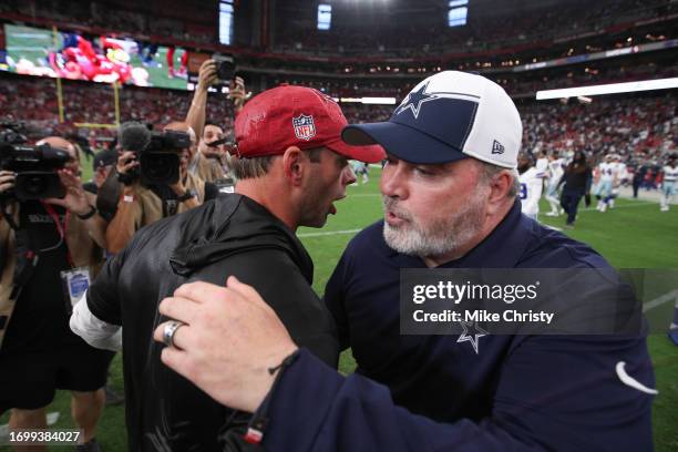 Head coach Jonathan Gannon of the Arizona Cardinals embraces Head coach Mike McCarthy of the Dallas Cowboys following the game at State Farm Stadium...