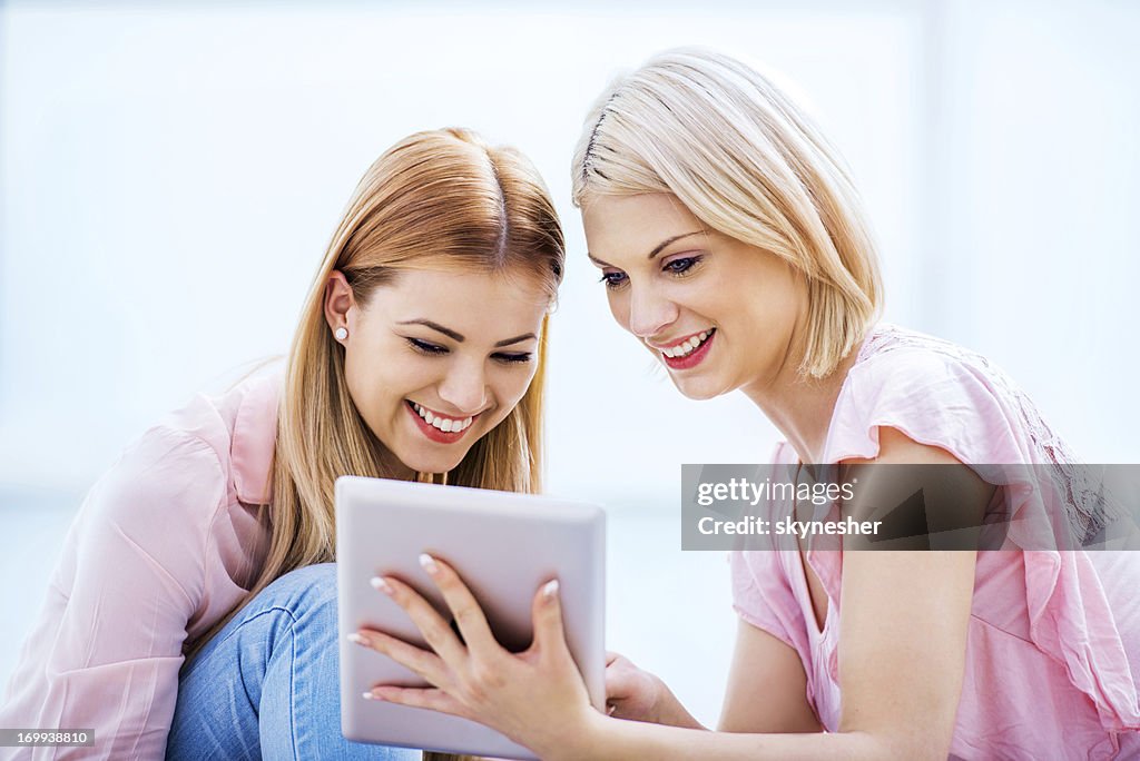 Two young women using a digital tablet