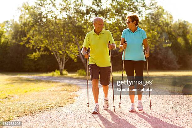 happy senior nordic walking für paare - walker stock-fotos und bilder