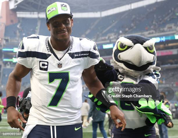 Geno Smith of the Seattle Seahawks celebrates Blitz, Seattle's mascot, after Seattle's 37-27 win against the Carolina Panthers at Lumen Field on...