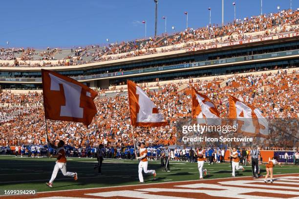 Texas flags are carried by the cheerleaders after a touchdown during the Big 12 football game between Texas Longhorns and Kansas Jayhawks on...