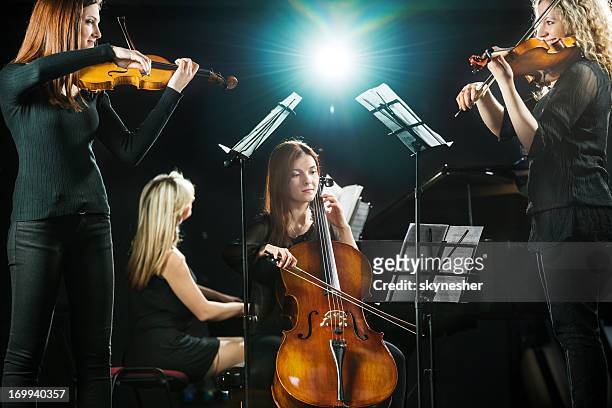 female orchestra. - musical quartet stock pictures, royalty-free photos & images