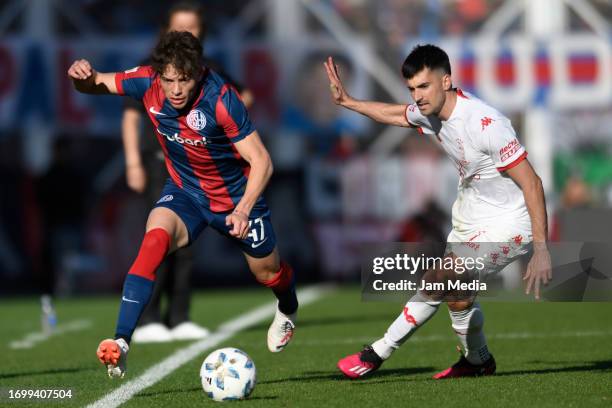 Agustin Giay of San Lorenzo controls the ball under pressure from Ignacio Pussetto of Huracan during a match between San Lorenzo and Huracan as part...