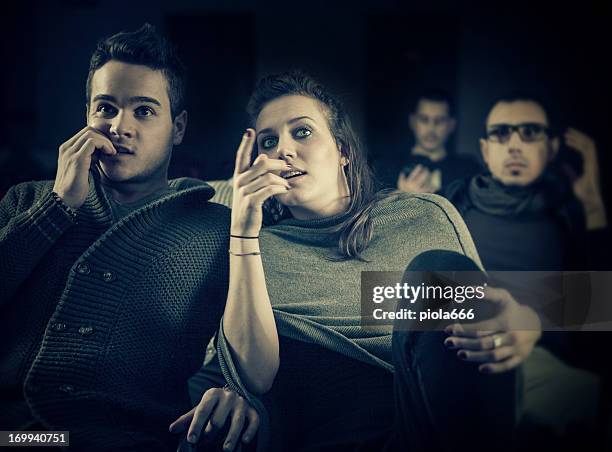 couple scared at the cinema, watching horror movie - amour 2012 film stock pictures, royalty-free photos & images