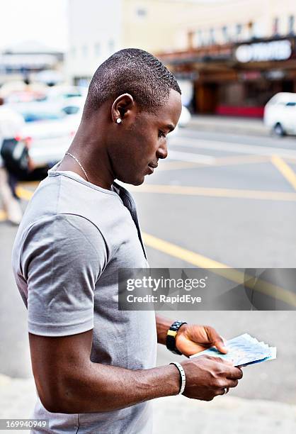 man in city street with new south african mandela banknotes - south africa money stock pictures, royalty-free photos & images