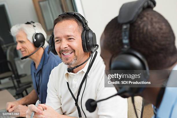 smiling sportscasters discussing game in the media box - sports commentator stock pictures, royalty-free photos & images