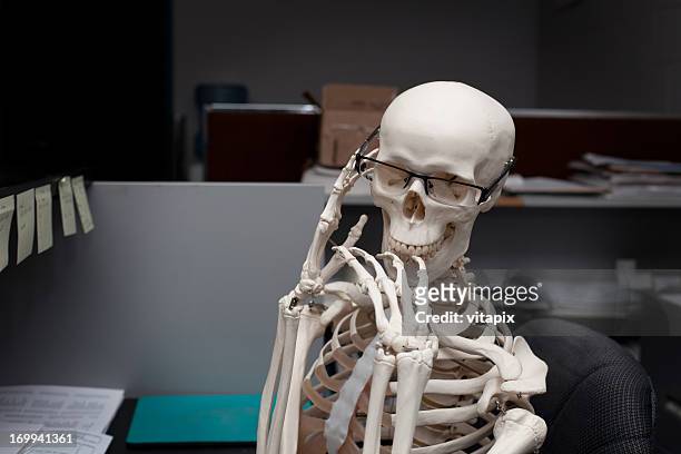 thinking skeleton at work - funny skeleton stockfoto's en -beelden