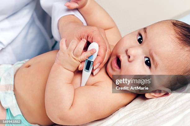 checking baby's temperature - fever stock pictures, royalty-free photos & images