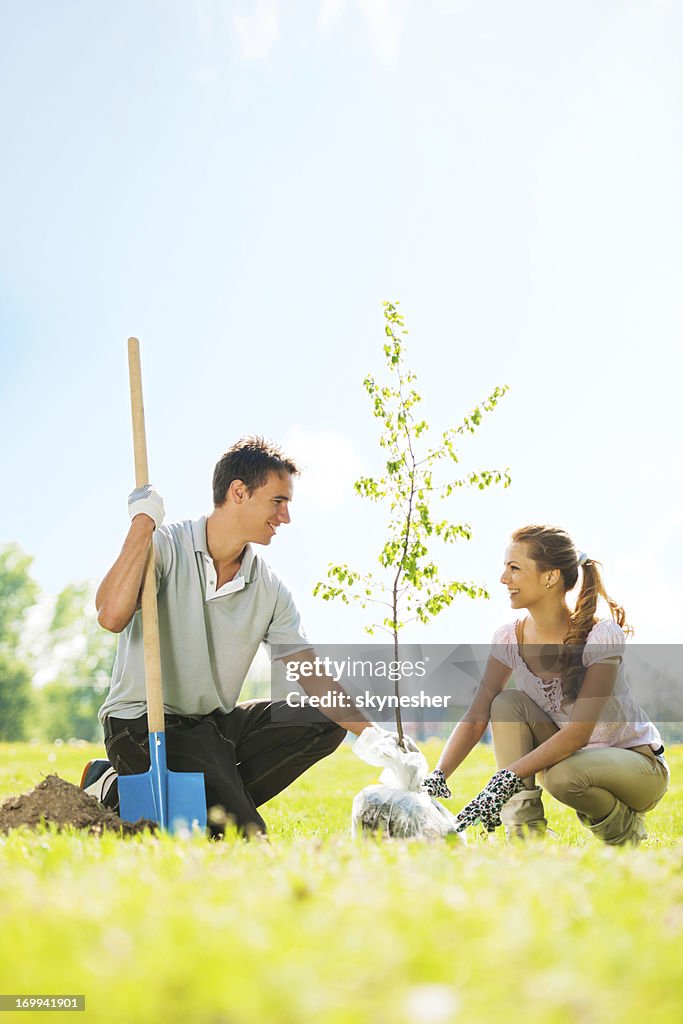 Beautiful couple planting a tree.