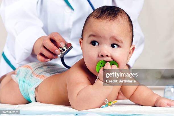 doctor checking baby with stethoscope - doctor gripping stock pictures, royalty-free photos & images
