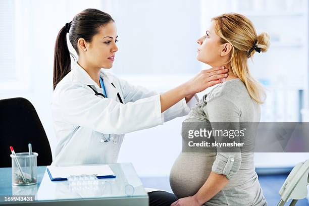 mujer médico examinar su paciente embarazada. - goiter fotografías e imágenes de stock