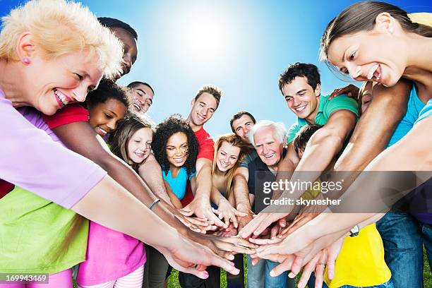 group of people standing in circle against the blue sky. - volunteer hands colorful stock pictures, royalty-free photos & images