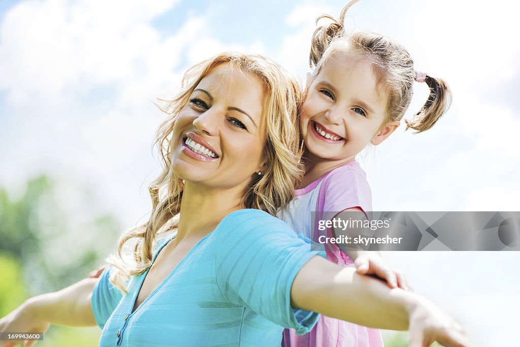 Beautiful mother and daughter against the sky.