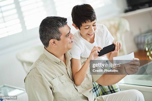 niño y padre de depositar bank plaza mediante teléfono inteligente - bank deposit slip fotografías e imágenes de stock