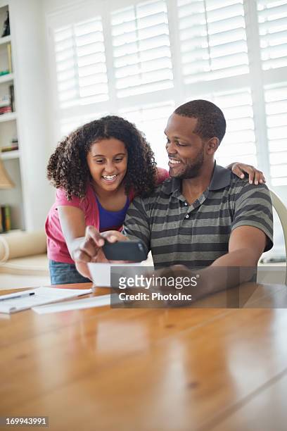 padre e hija mediante teléfono inteligente para depósito de banco múltiple - bank deposit slip fotografías e imágenes de stock