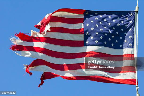 tattered american flag, still flying free and proud - verval stockfoto's en -beelden
