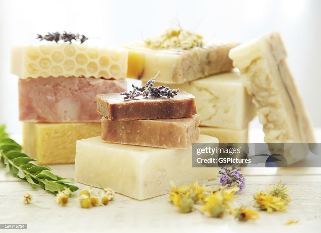 Stacks homemade organic bars of soap with lavender on top