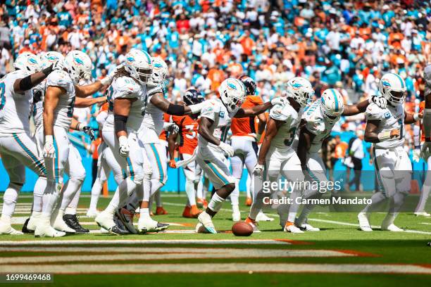 Tyreek Hill of the Miami Dolphins and Raheem Mostert celebrate with teammates after Mostert's rushing touchdown during the second quarter against the...
