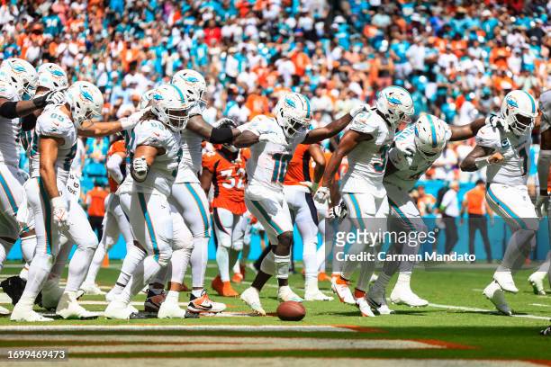 Tyreek Hill of the Miami Dolphins and Raheem Mostert celebrate with teammates after Mostert's rushing touchdown during the second quarter against the...