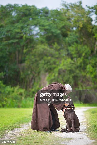 monaco e il suo cane - prete foto e immagini stock