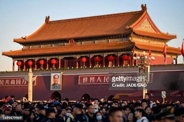 People attend a flag-raising ceremony to mark China's National Day at Tiananmen Square in Beijing on October 1, 2023.