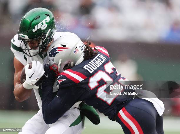 Allen Lazard of the New York Jets is tackled by Kyle Dugger of the New England Patriots at MetLife Stadium on September 24, 2023 in East Rutherford,...
