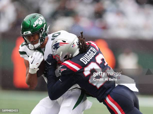 Allen Lazard of the New York Jets is tackled by Kyle Dugger of the New England Patriots at MetLife Stadium on September 24, 2023 in East Rutherford,...