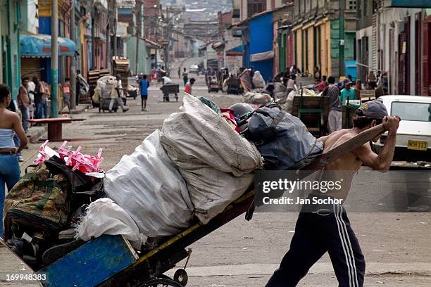 Colombian garbage recollector pulls his fully loaded cart on the street in the slum of Calvario on 5 April 2004 in Cali, Colombia. Calvario, a slum...