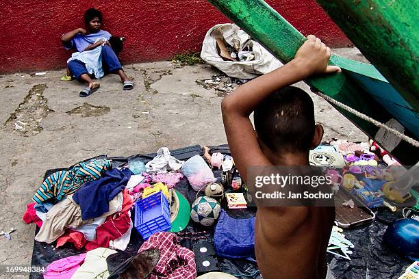 Young Colombian mother with her babygirl sells rummage and used clothes from garbage dumps in the slum of Calvario on 3 April 2004 in Cali, Colombia....